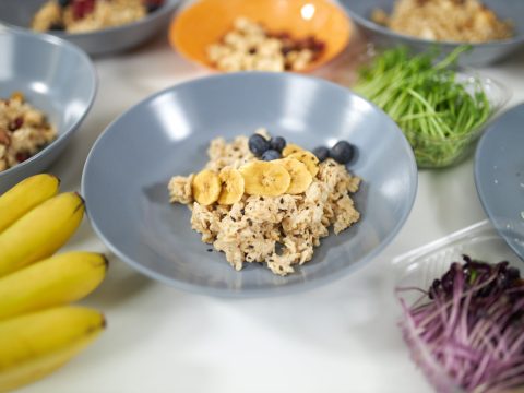 Close up of tasty and healthy porridge with fresh fruits in beautiful blue plate. Concept of process cooking delicious dish at home with tasty ingredients and fresh vegetables and fruits.